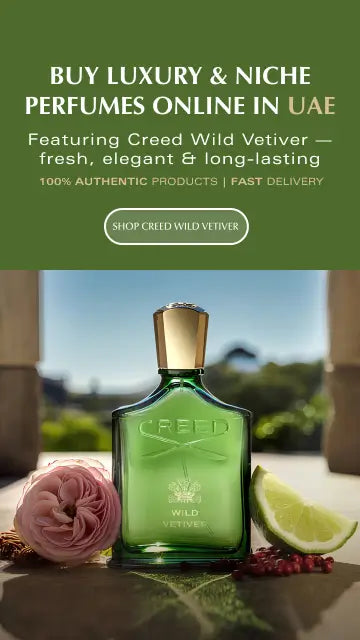 A green Creed Wild Vetiver perfume bottle with a gold cap, styled on a stone surface with a pink rose, lime wedge, and pomegranate seeds. Above the bottle, a dark green banner reads 'BUY LUXURY & NICHE PERFUMES ONLINE IN UAE' and 'Featuring Creed Wild Vetiver.